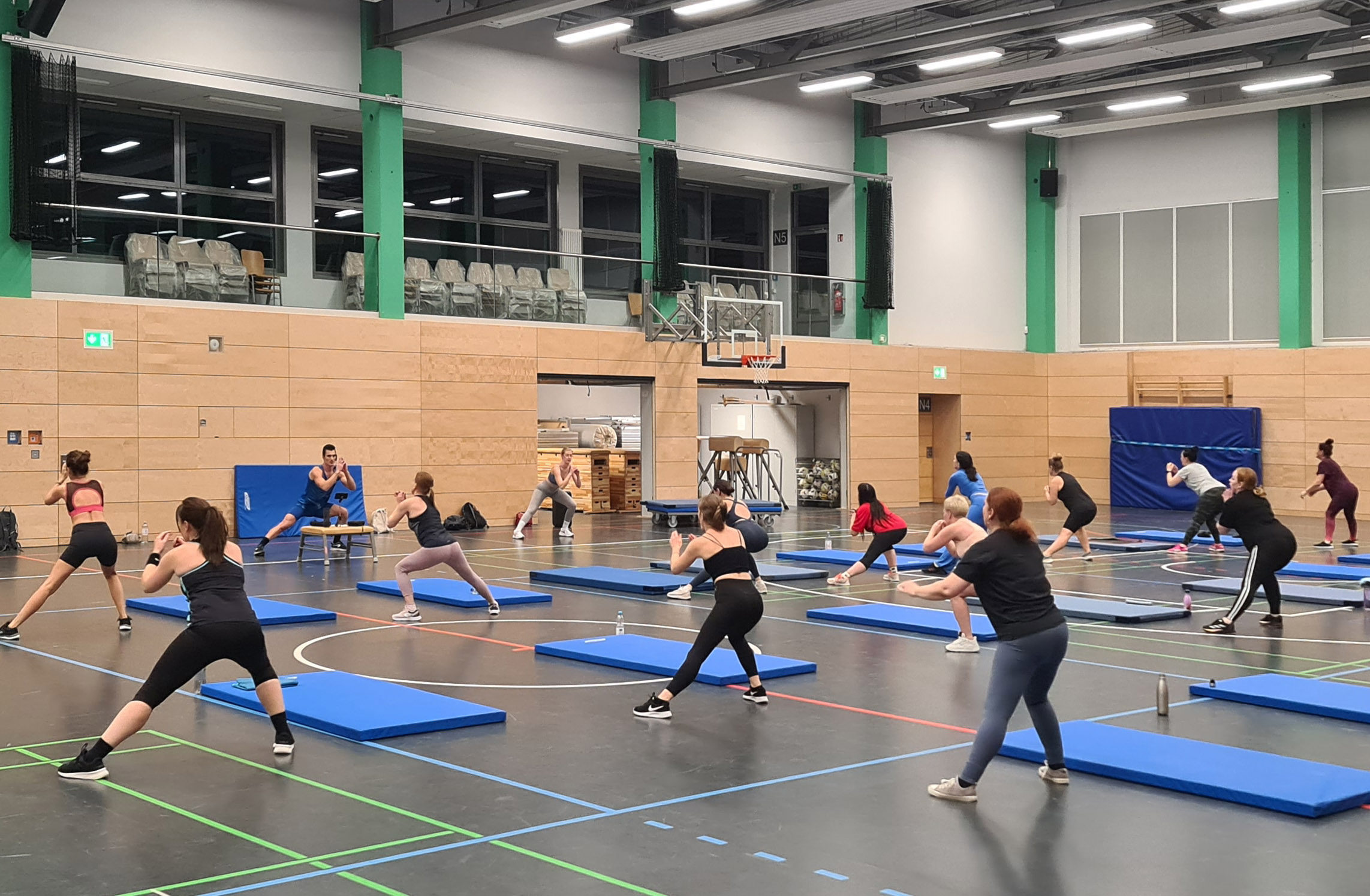 In einer großen Turnhalle machen viele Frauen Gymnastik.